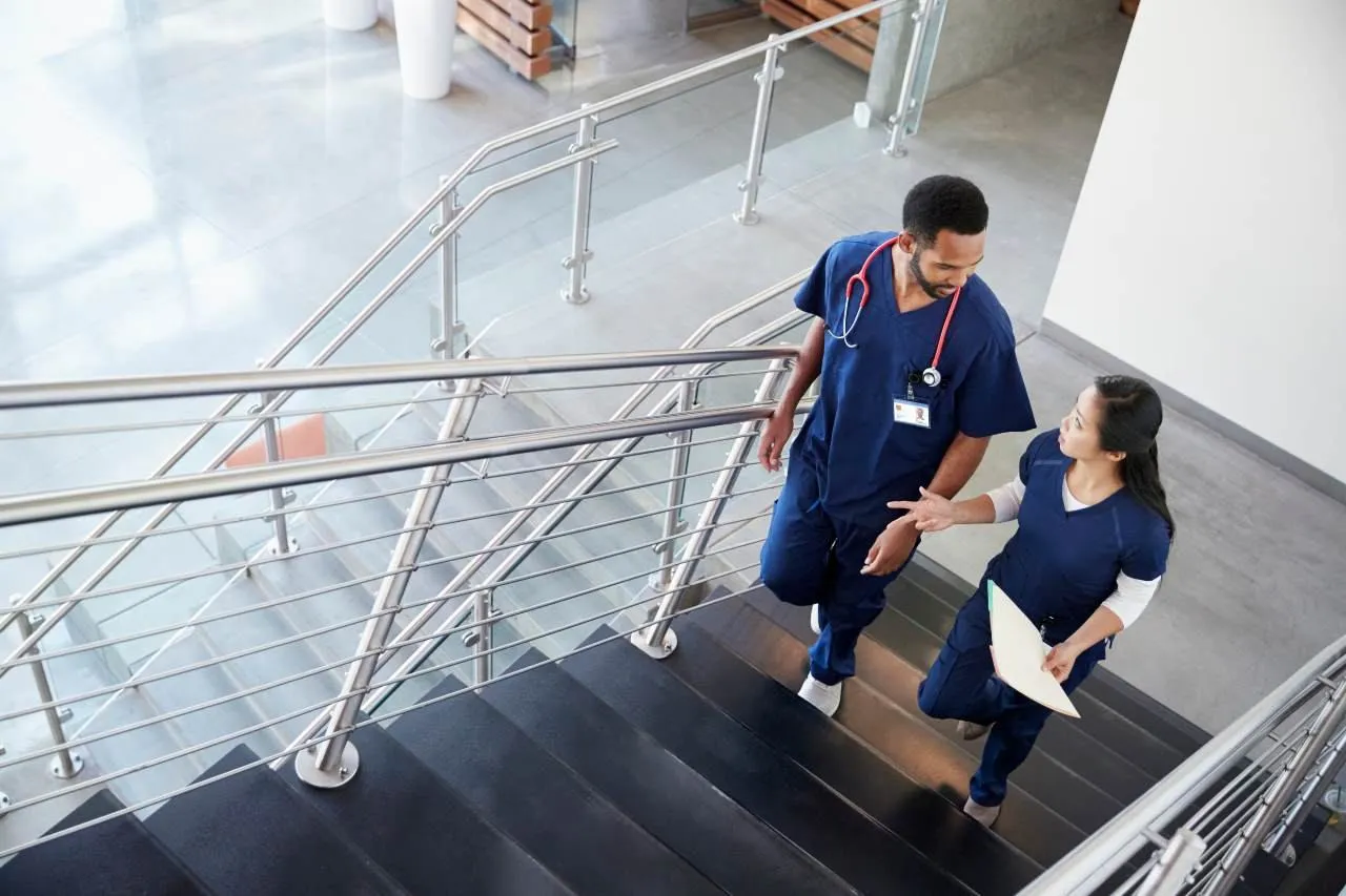 two nurses walking in a hospital to get to med surg unit